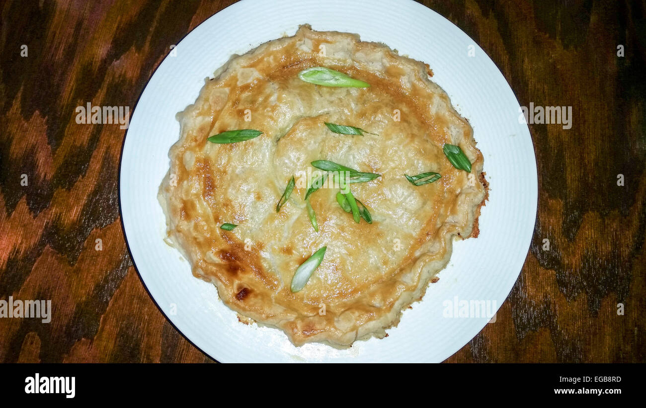 Très gros pâté au poulet garni d'oignons verts effilées. Banque D'Images