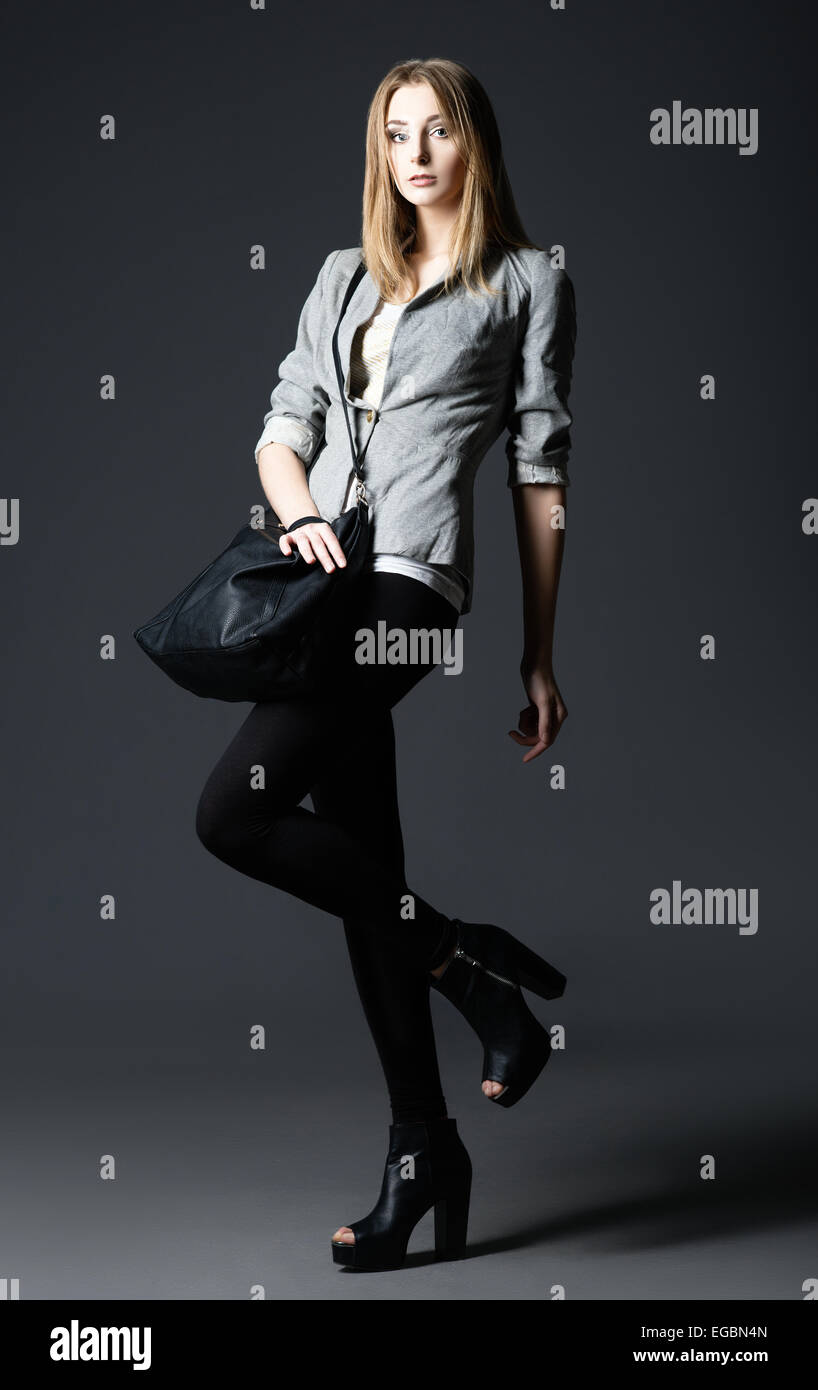 Fashion Studio shot : une belle jeune femme en leggings et veste, sac à main en Banque D'Images