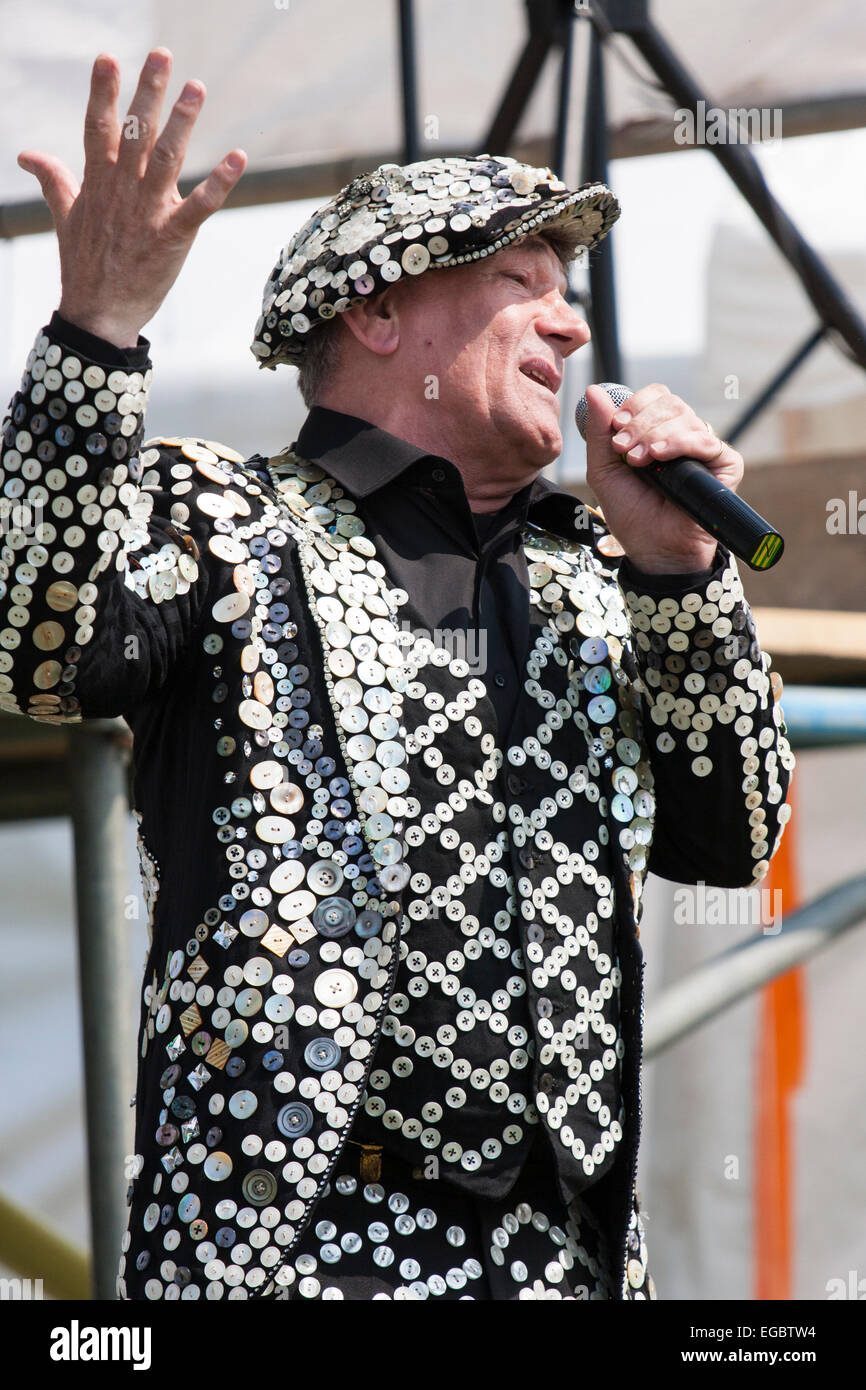 Mickie Driver, vêtu d'un gilet, d'une veste et d'un chapeau de roi pélé, chantant lors d'un événement nostalgique des années 1940 en plein air avec un microphone à main. Banque D'Images