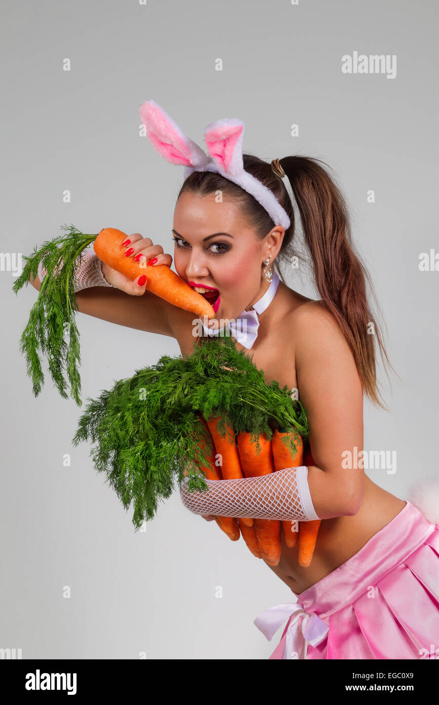 Jolie femme en costume de lapin aux carottes Banque D'Images