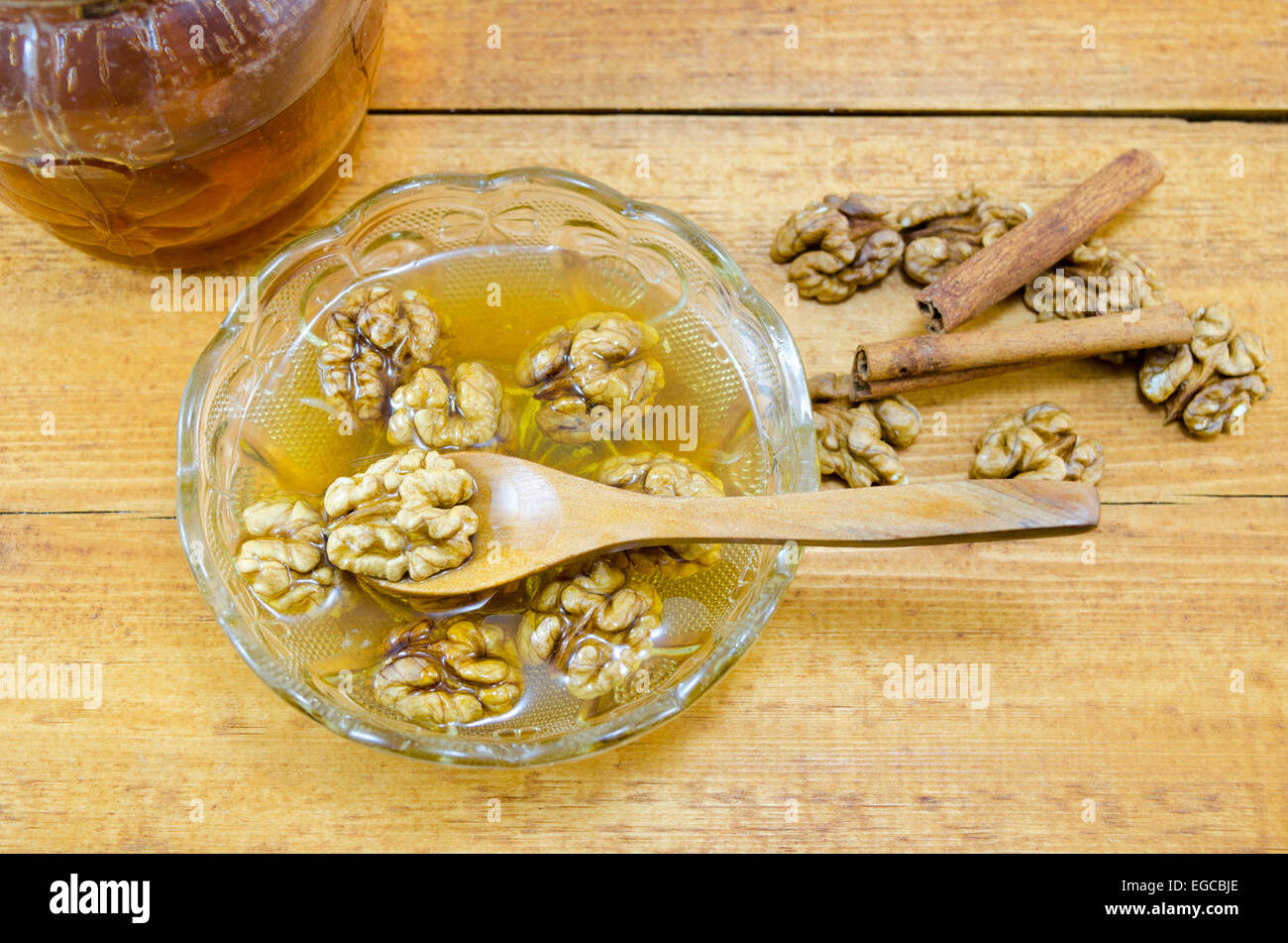 Miel Noix et de la cannelle dans un pot sur une table en bois Banque D'Images