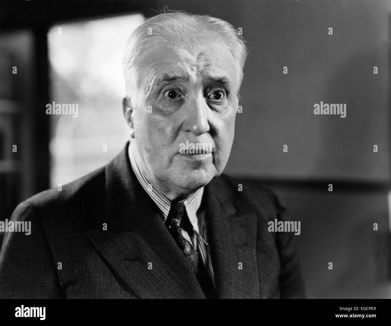 Années 1940 Années 1950 PORTRAIT PLUS MATURE MAN IN SUIT AVEC LES concernés ont souligné expression triste les yeux grands ouverts fixant STARE Banque D'Images