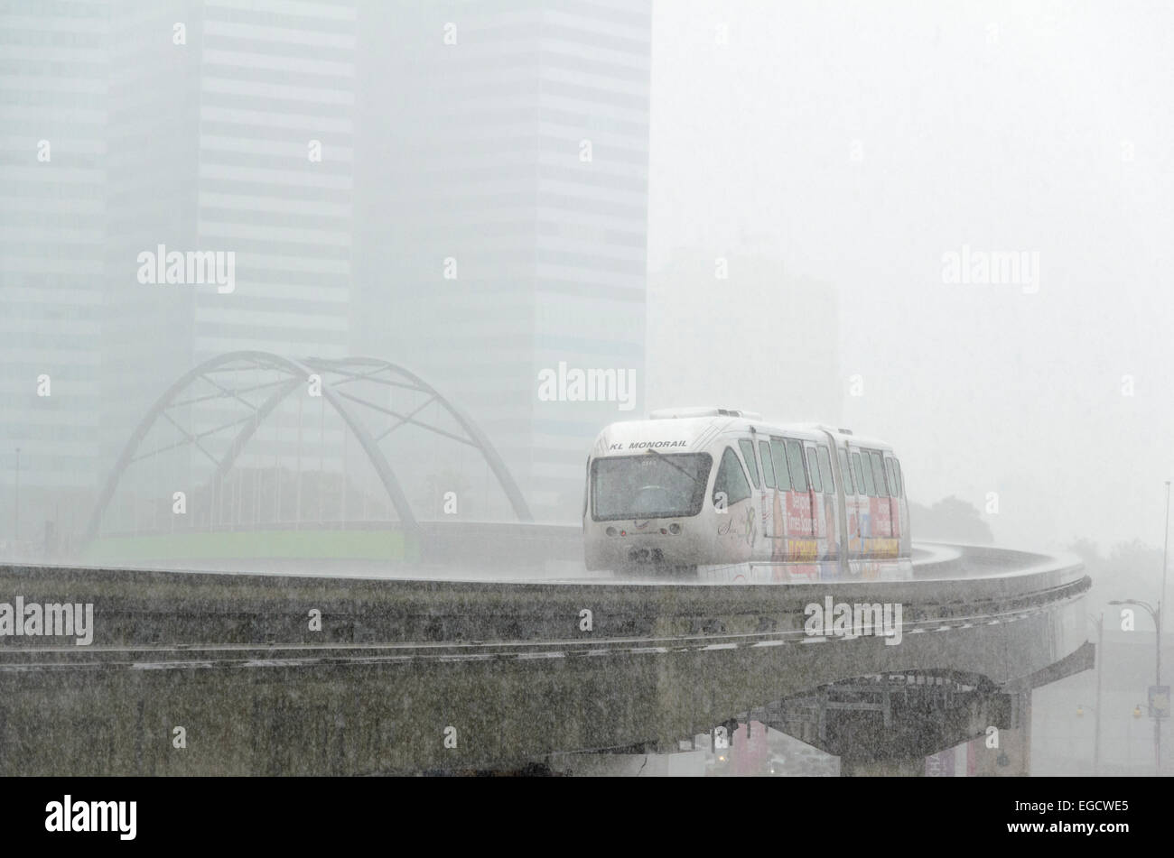 Train monorail asiatique dans une soudaine averse tropicale ; les pluies torrentielles à la saison des pluies (saison humide) en Asie du sud-est Banque D'Images