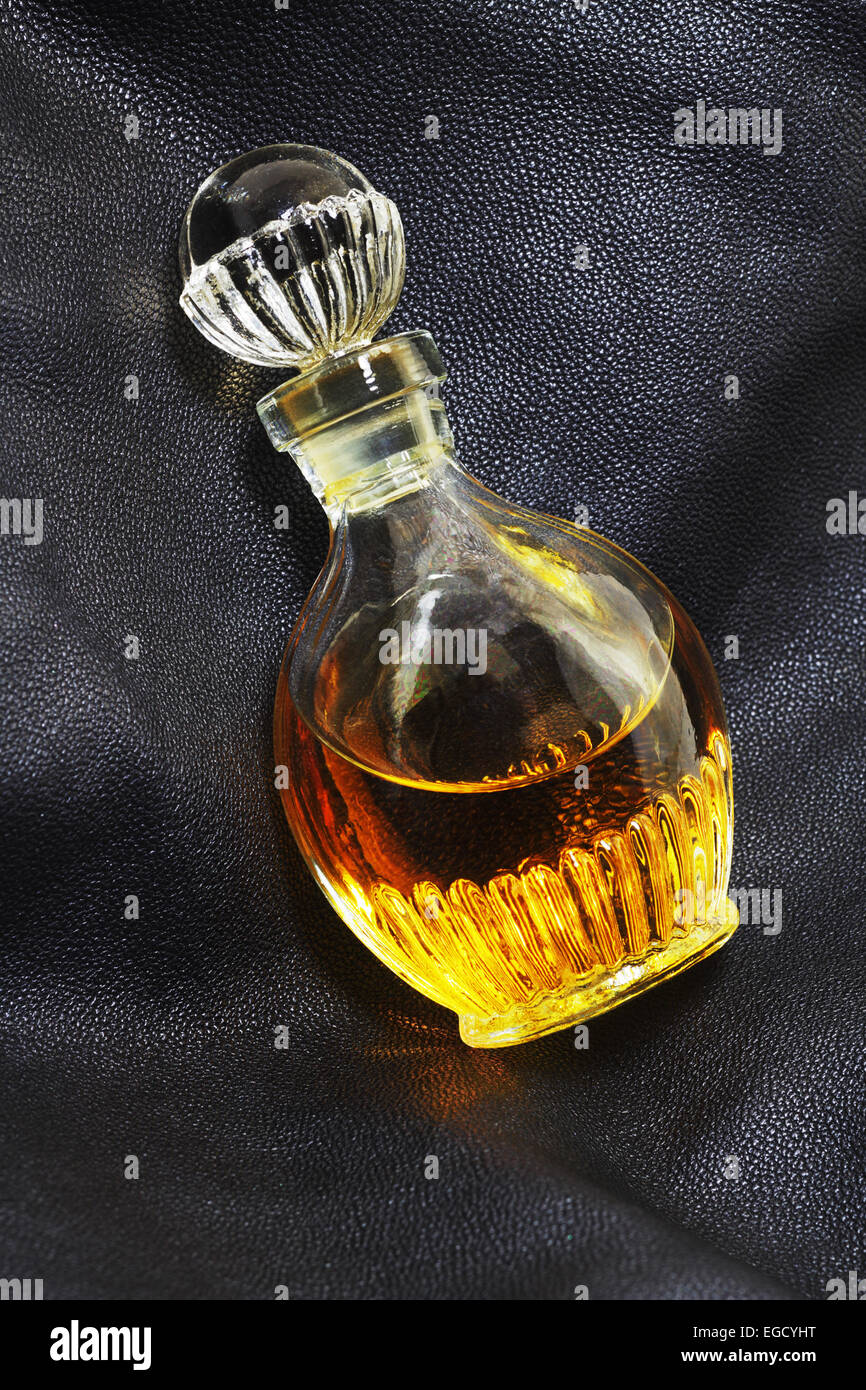 Vintage flacon de parfum sur un fond en cuir foncé Banque D'Images