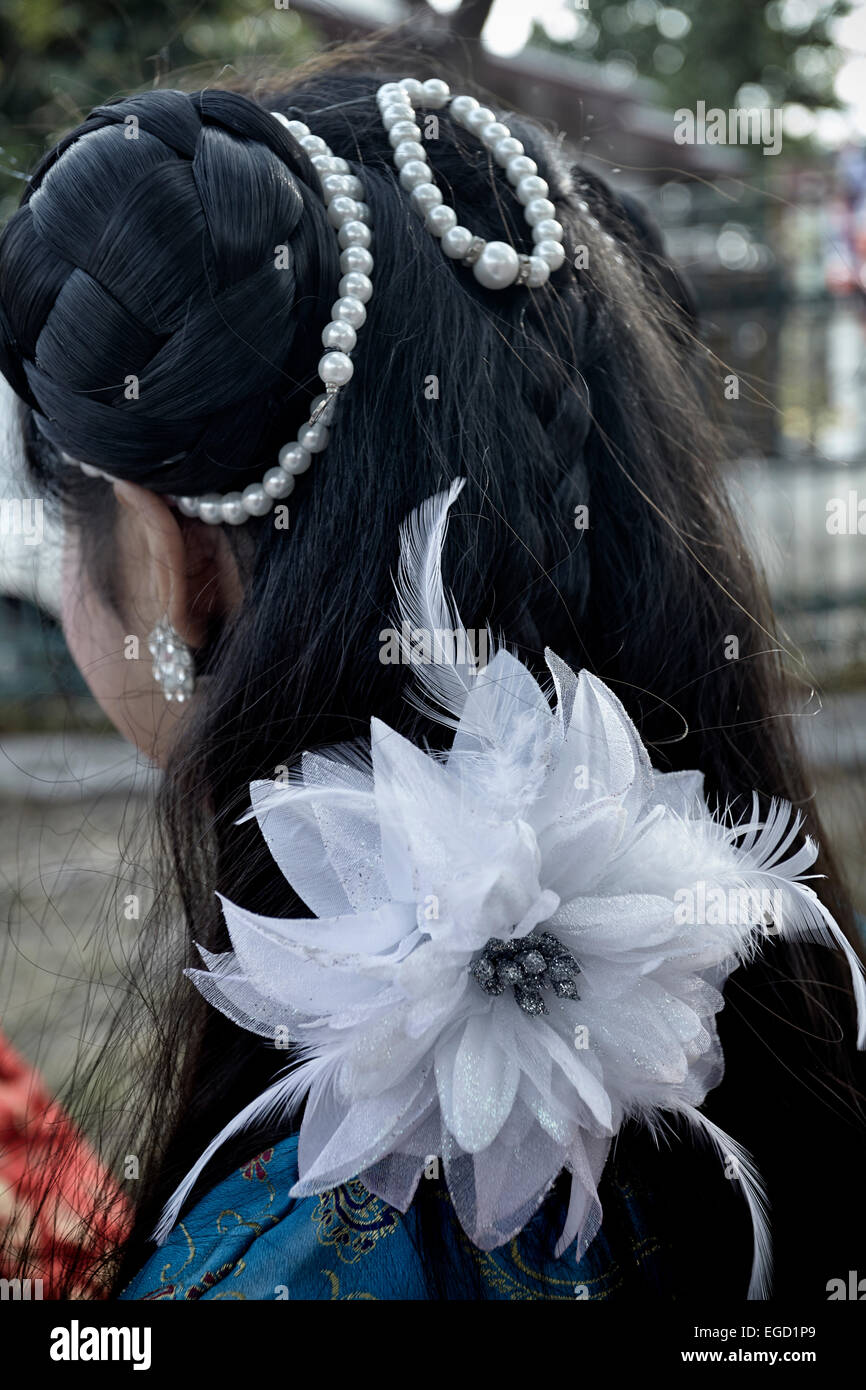 Fleurs artificielles. Cheveux féminins ornés de perles et de fleurs artificielles en spray. Thaïlande S. E. Asie Banque D'Images