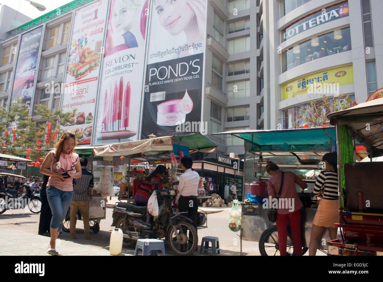 Les femmes travaillent à un panier alimentaire mobile vendant des aliments de rue à proximité d'un centre commercial sur une rue bondée à Phnom Penh, Cambodge. Banque D'Images