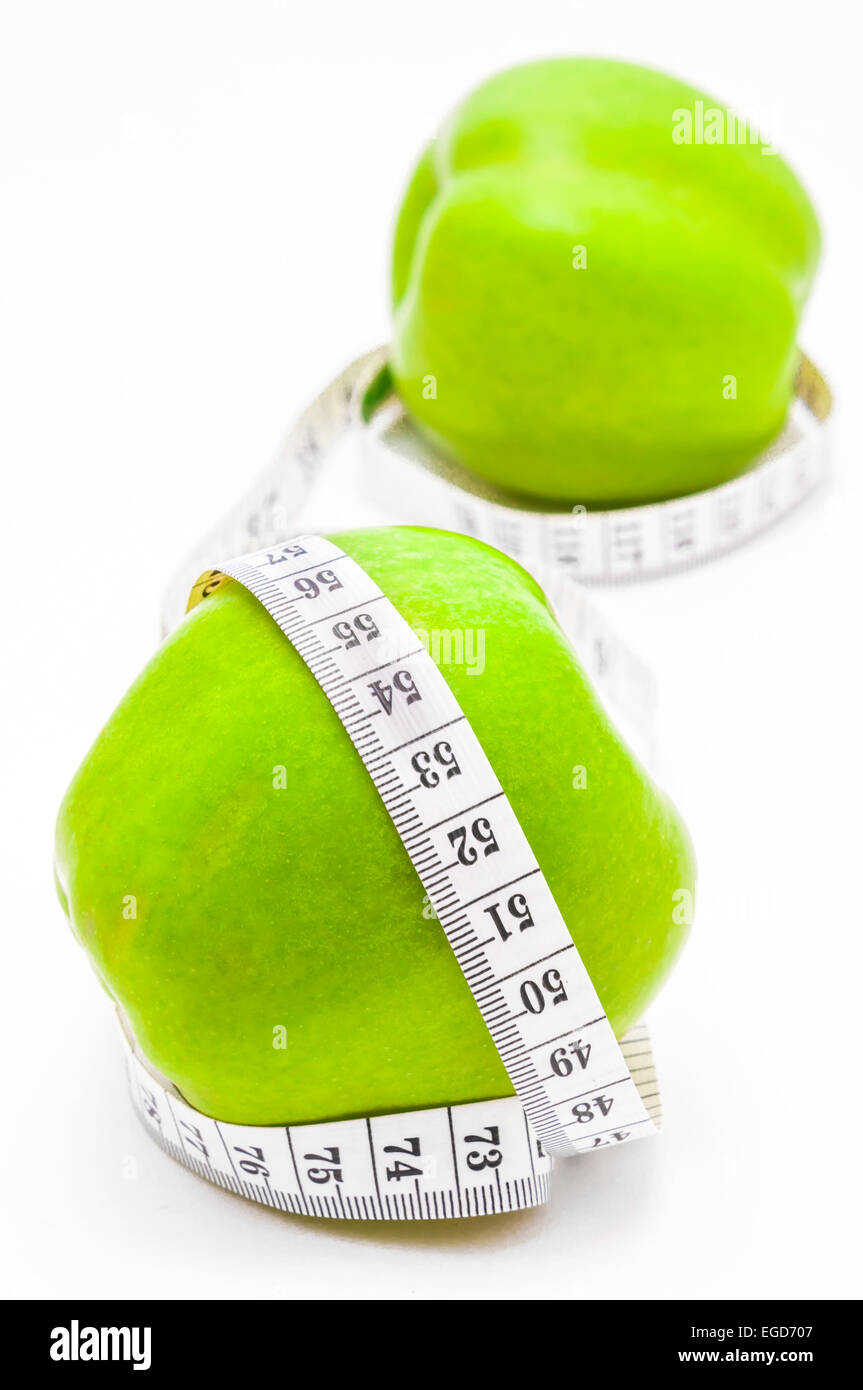 Pomme verte avec ruban à mesurer on white Banque D'Images