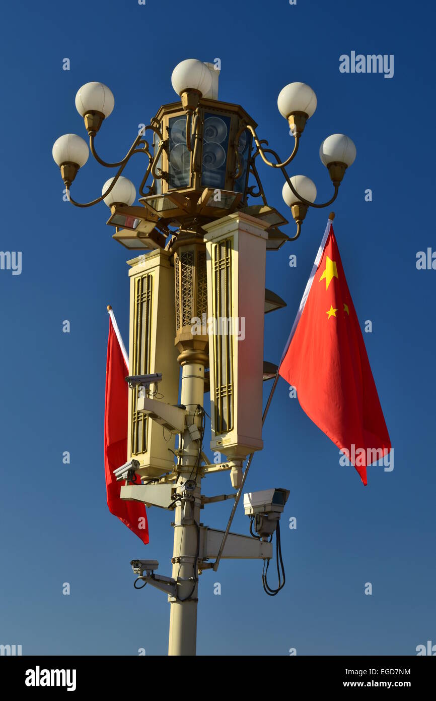 Agitant des drapeaux chinois sur un lampadaire avec des caméras de surveillance et des haut-parleurs Banque D'Images