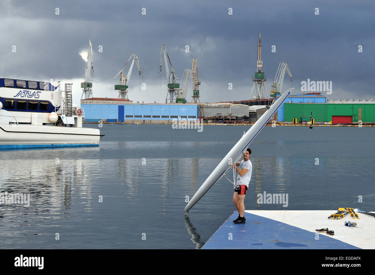 Jeune homme avec une yole dans le port, Pula, Istrie, Croatie Banque D'Images