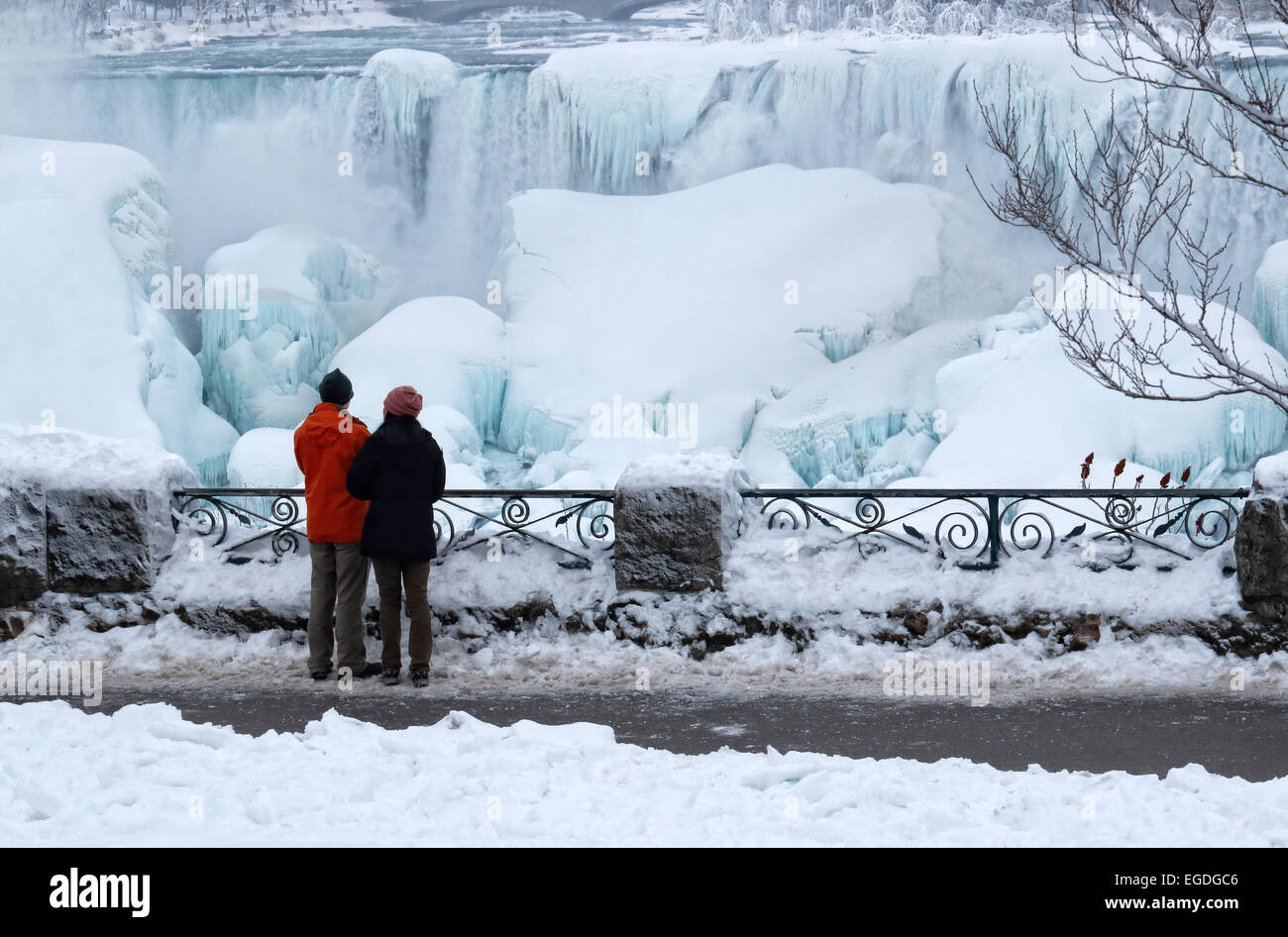 Frozen Niagara Falls Chutes américaines avec un couple d'admirer sa beauté sur la rive de la rivière Niagara sur le côté canadien Banque D'Images