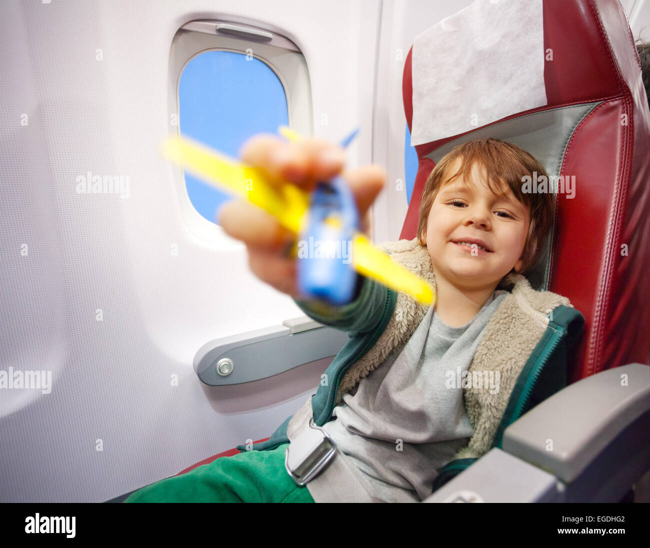 Smiling boy with toy plane flying sur avion à réaction Banque D'Images