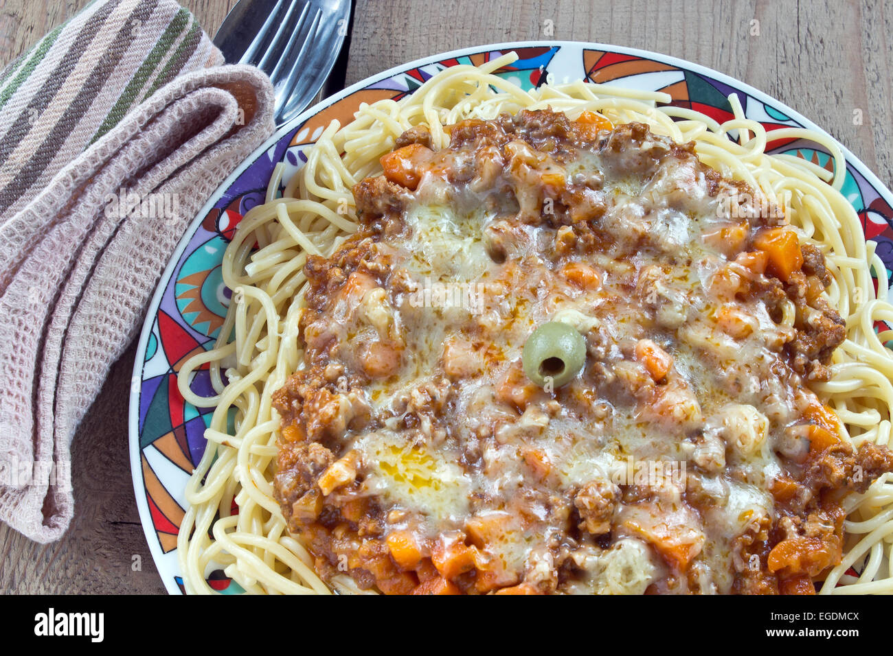 Spaghettis à la bolognaise sur plaque avec fourchette et cuillère sur la table Banque D'Images