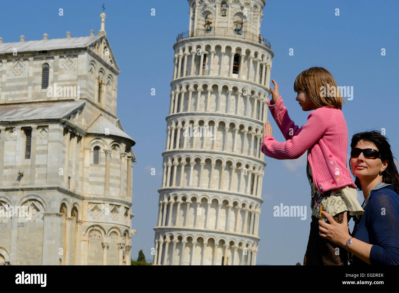 Femme et enfant soutenant la Tour Penchée de Pise, Pise, Toscane, Italie Banque D'Images