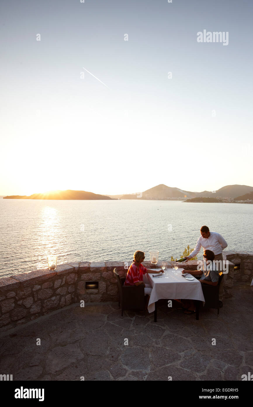 Couple de dîner sur une terrasse d'un restaurant, vue sur la baie de Budva, Aman Sveti Stefan, Sveti Stefan, Budva, Monténégro Banque D'Images