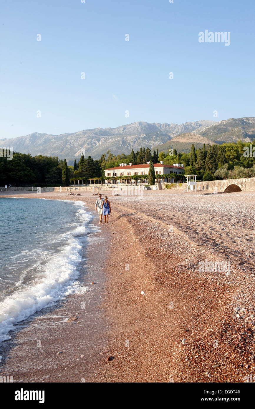 Couple dans la plage, la Villa Milocer en arrière-plan, Aman Sveti Stefan, Sveti Stefan, Budva, Monténégro Banque D'Images