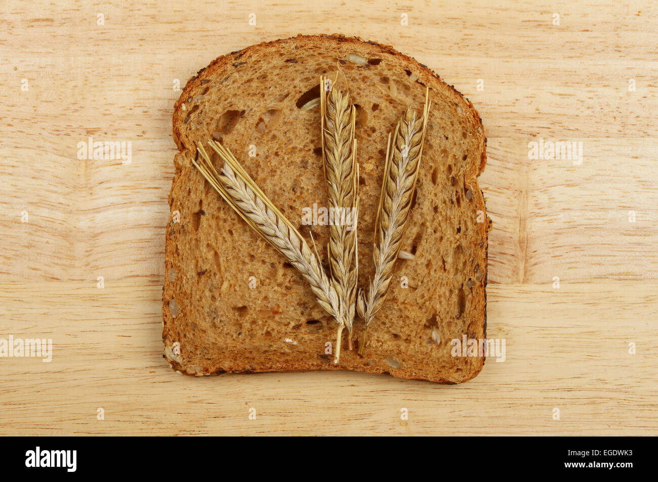 Les oreilles d'orge sur une tranche de pain gris sur une planche en bois Banque D'Images