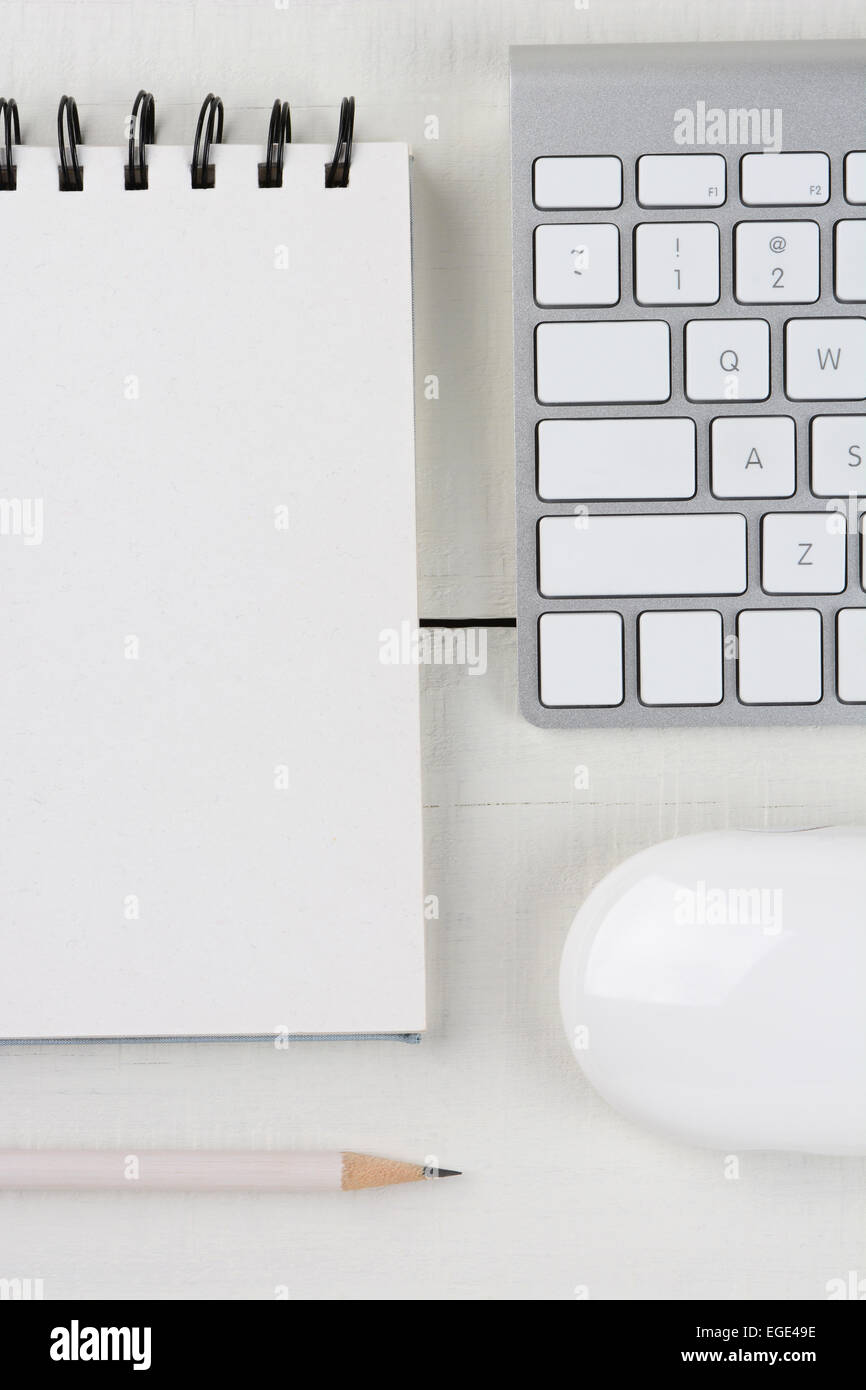 Image Gros plan vertical d'un bureau à la maison blanche 24 avec un clavier d'ordinateur, vierge de notes, un crayon blanc, et de la souris. Banque D'Images