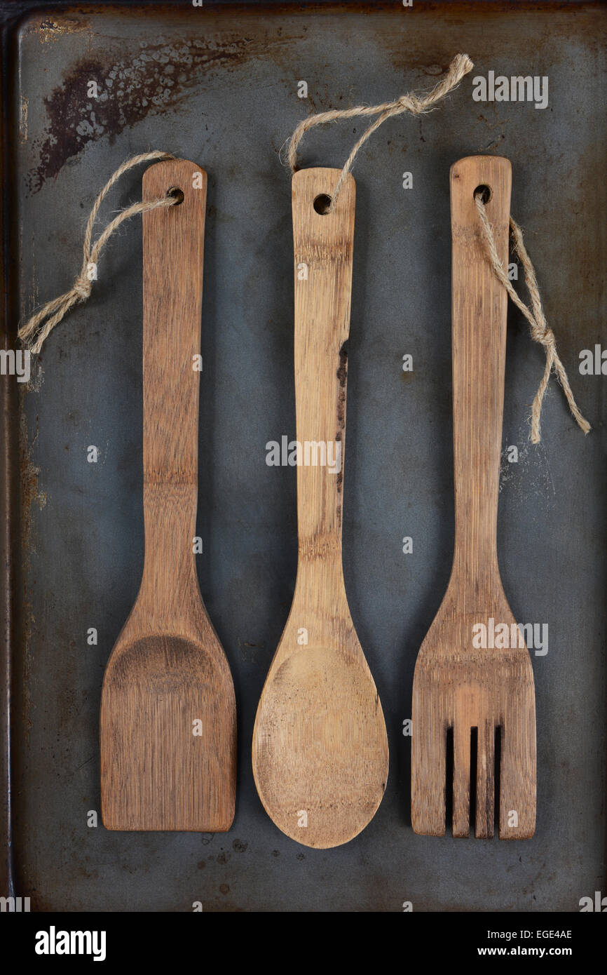 High angle shot de 3 ustensiles de cuisine en bois, fourchette, cuillère et  spatule, avec ficelle à travers le trou de la poignée sur un métal utilisé  b Photo Stock - Alamy