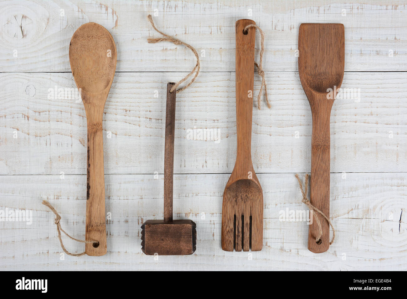 High angle libre d'une cuillère en bois, fourchette et spatule, maillet sur une table de cuisine blancs. Format horizontal. Banque D'Images