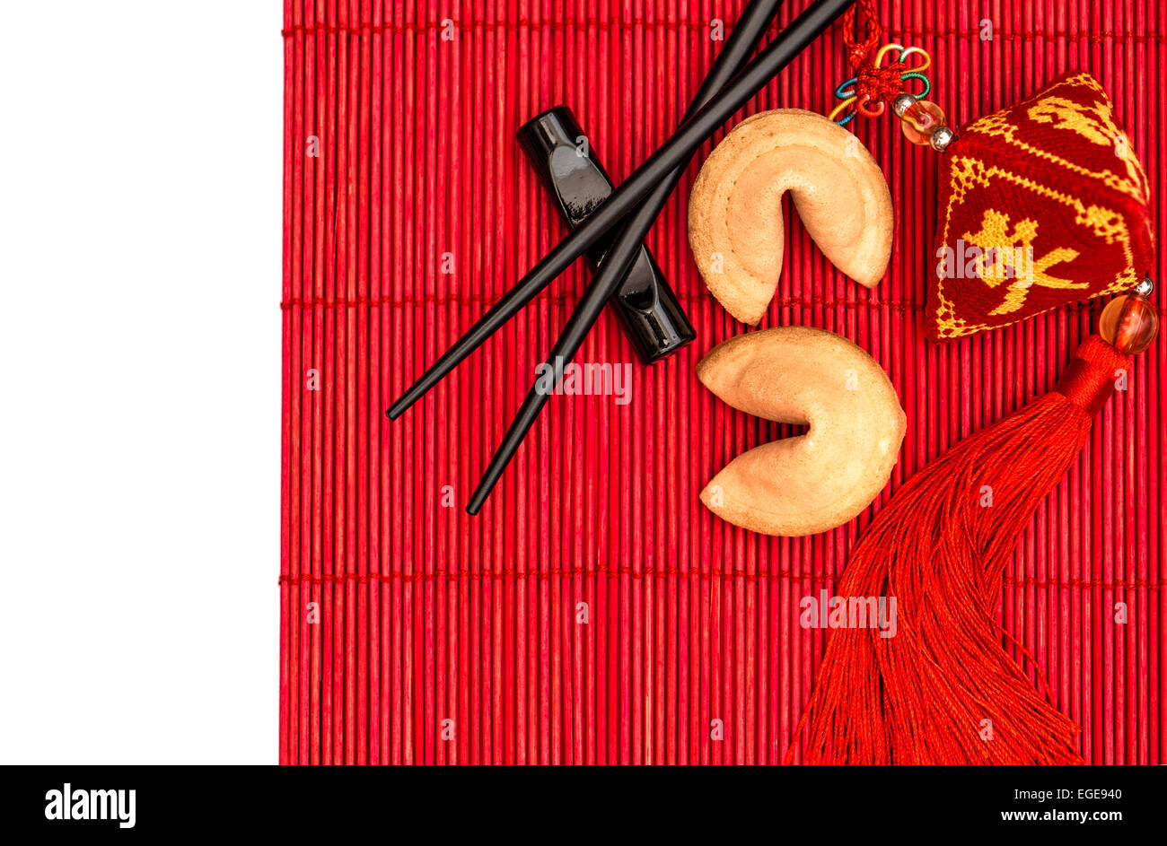 Table de style asiatique avec réglage du nouvel an chinois porte-bonheur, fortune cookies et baguettes de bambou rouge mat Banque D'Images