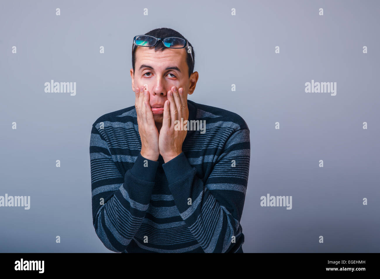 Homme d'apparence des cheveux noirs s'étire les yeux avec son h Banque D'Images