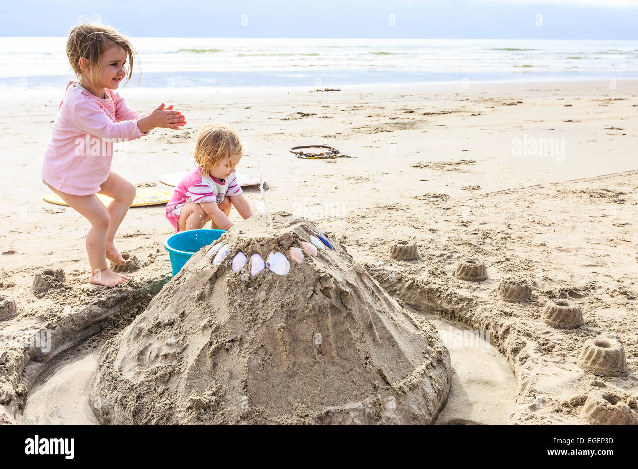 Deux jeunes filles, les tout-petits, jouant avec un château de sable sur la plage, la Namibie, Langstrand Banque D'Images