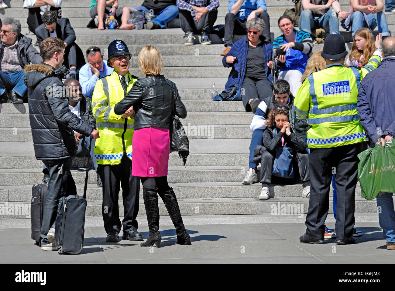 Londres, Angleterre, Royaume-Uni. Trafalgar Square - officier de police dans la Veste haute visibilité au public francophone Banque D'Images