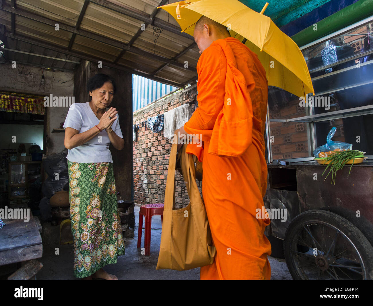 Phnom Penh, Phnom Penh, Cambodge. Feb 24, 2015. Une femme fait une offrande à un moine bouddhiste dans le bâtiment blanc. Le bâtiment blanc, le premier immeuble d'appartements modernes à Phnom Penh, à l'origine, avait 468 appartements, et a été ouvert au début des années 1960. Le projet a été supervisé par Vann Molyvann, le premier architecte cambodgien fait ses études en France. Le bâtiment a été abandonnée au cours de l'occupation des Khmers rouges. Après les Khmers rouges ont été chassés de Phnom Penh en 1979, des artistes et des danseurs a déménagé dans le bâtiment blanc. © ZUMA Press, Inc./Alamy Live News Banque D'Images