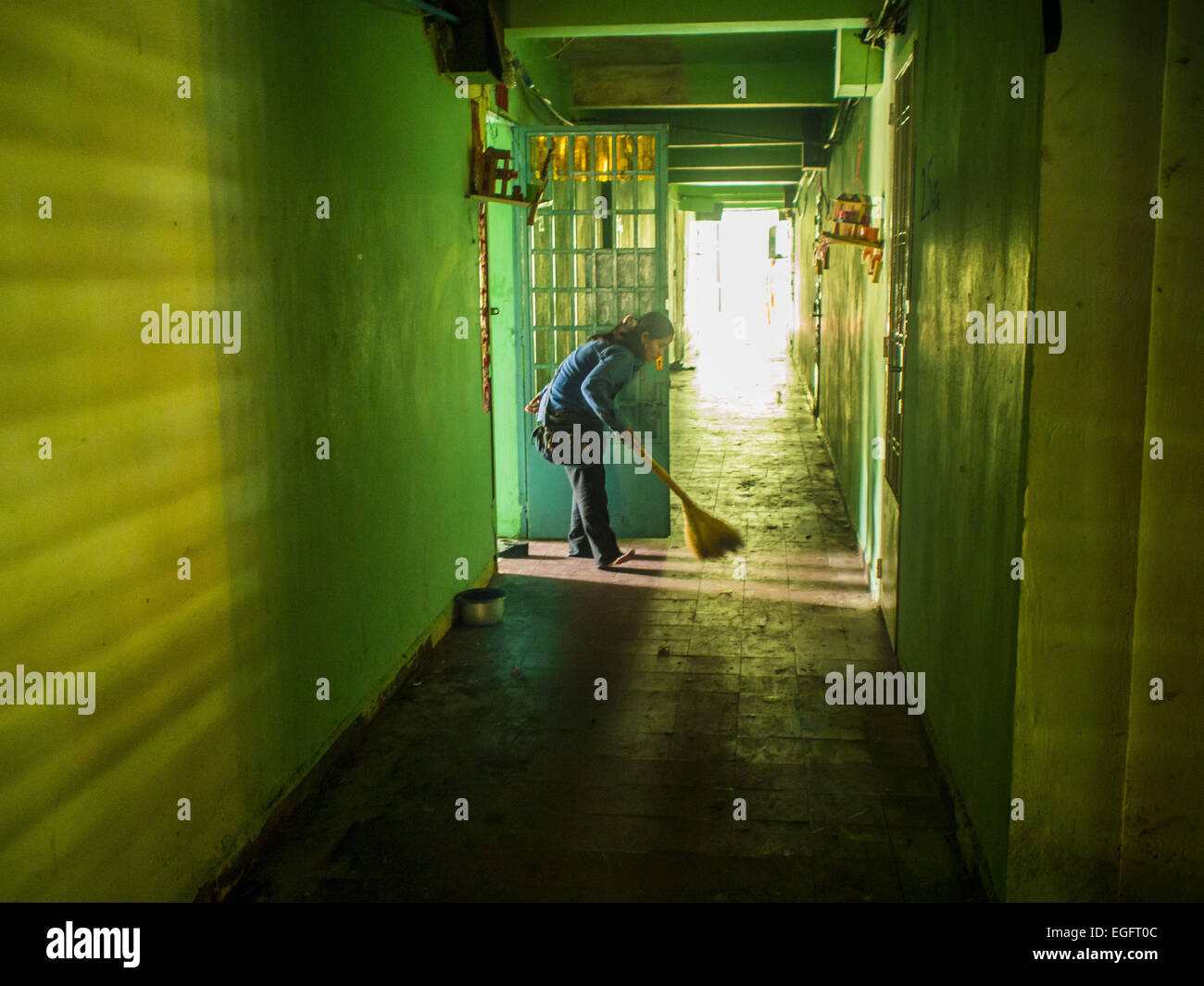 Phnom Penh, Phnom Penh, Cambodge. Feb 24, 2015. Une femme balaie le couloir en face de son appartement dans le bâtiment blanc. Le bâtiment blanc, le premier immeuble d'appartements modernes à Phnom Penh, à l'origine, avait 468 appartements, et a été ouvert au début des années 1960. Le projet a été supervisé par Vann Molyvann, le premier architecte cambodgien fait ses études en France. Le bâtiment a été abandonnée au cours de l'occupation des Khmers rouges. Après les Khmers rouges ont été chassés de Phnom Penh en 1979, des artistes et des danseurs a déménagé dans le bâtiment blanc. © ZUMA Press, Inc./Alamy Live News Banque D'Images