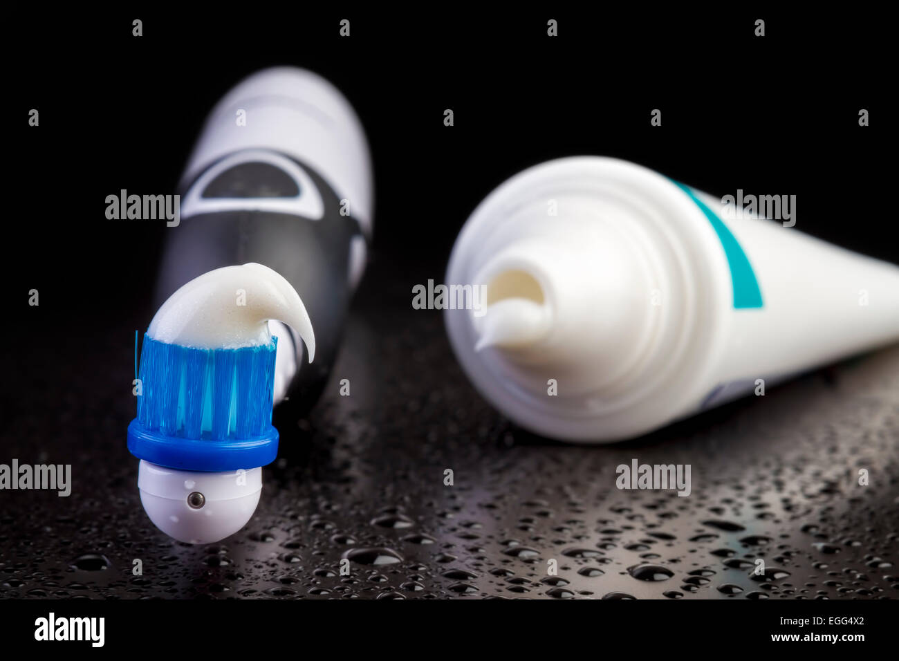 Brosse à dents avec du dentifrice noir sur fond noir Banque D'Images