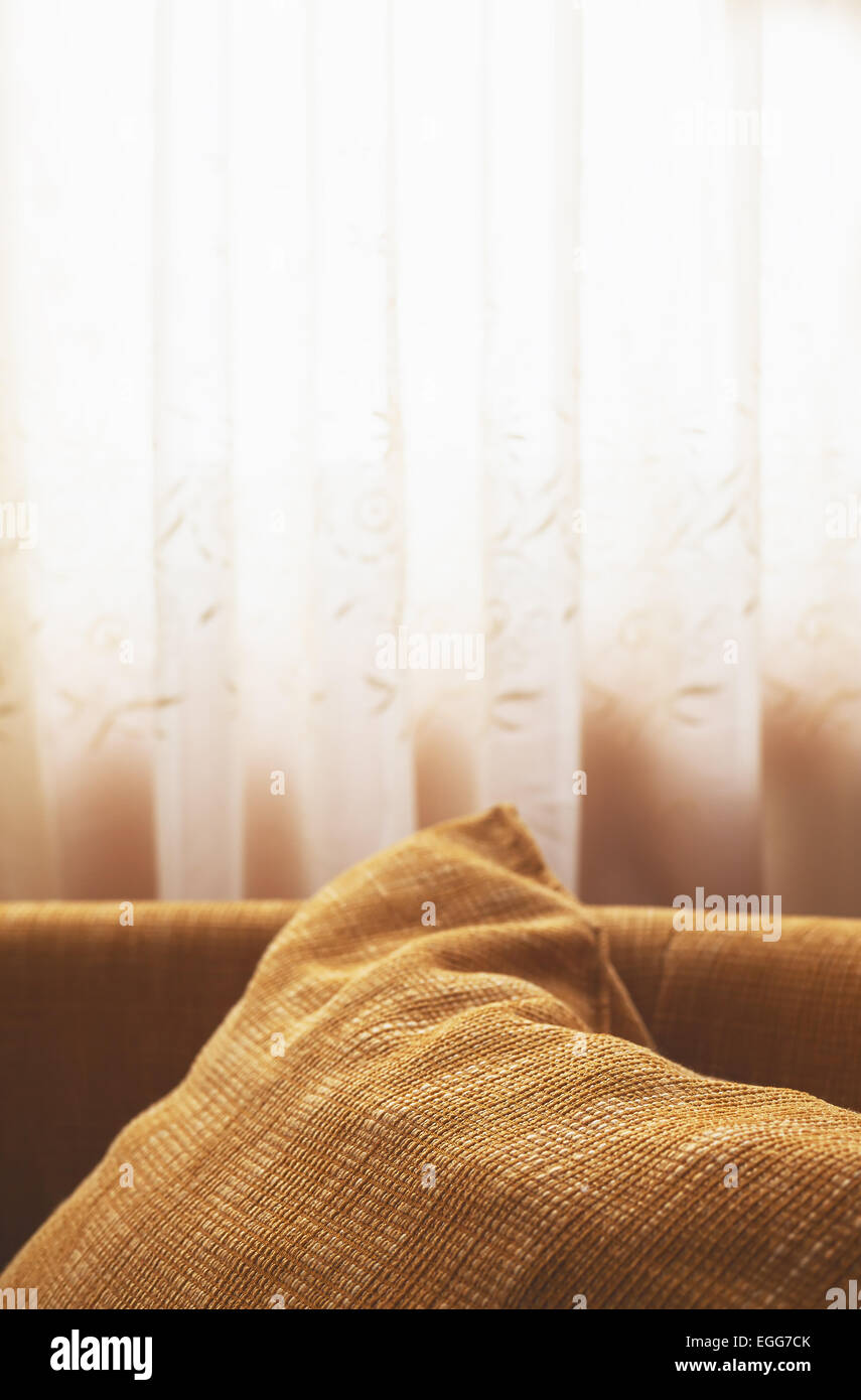 Juste un détail derrière la fenêtre, chambre intérieur, big brown oreiller à l'avant et des rideaux blancs en arrière-plan. Banque D'Images