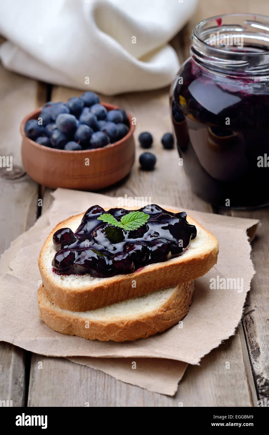 Confiture sur des toasts de pain sur table en bois Banque D'Images