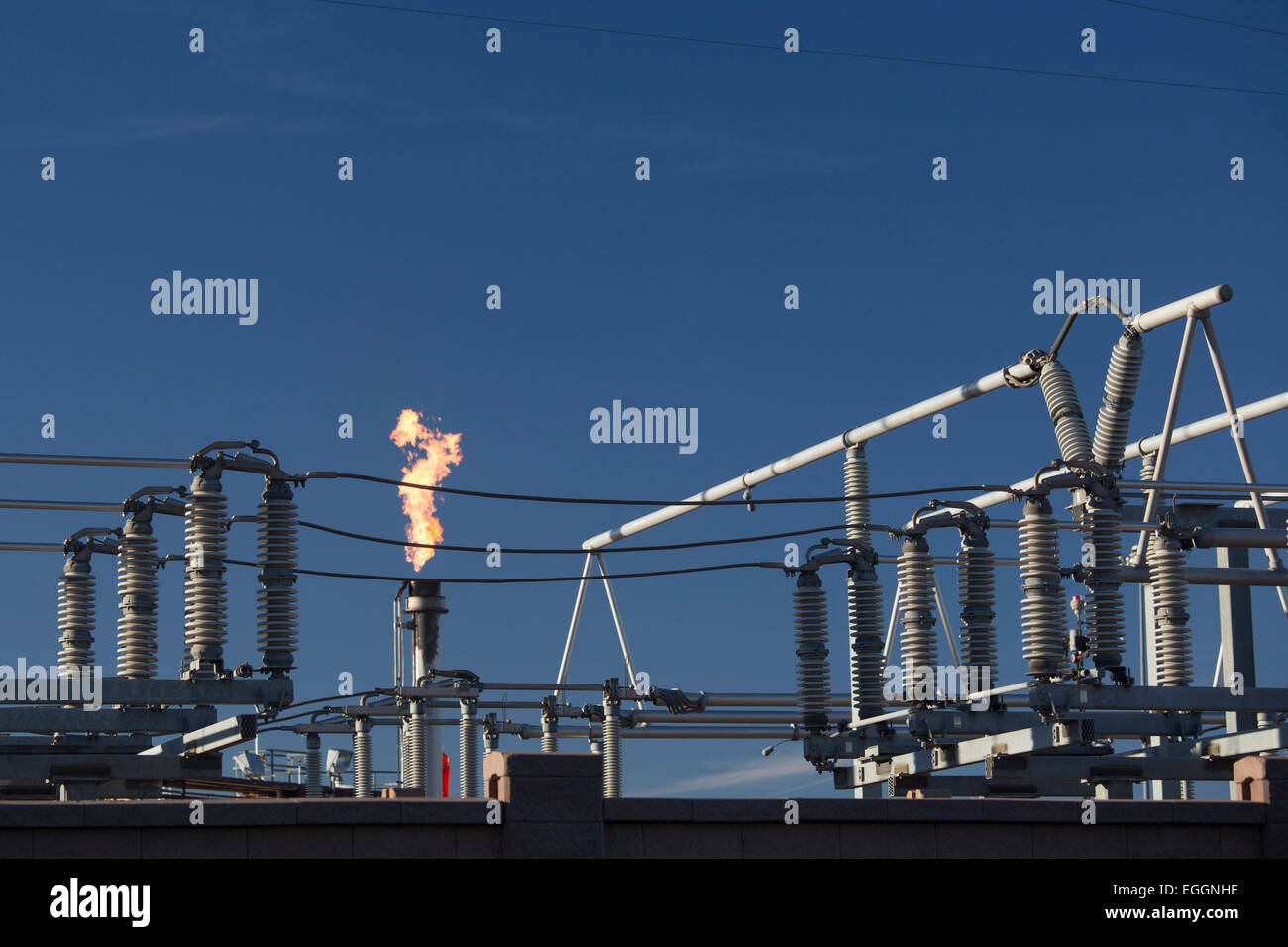 Denver, Colorado - une torchère brûle du gaz à près de matériel électrique à la raffinerie de pétrole de Suncor Énergie. Banque D'Images