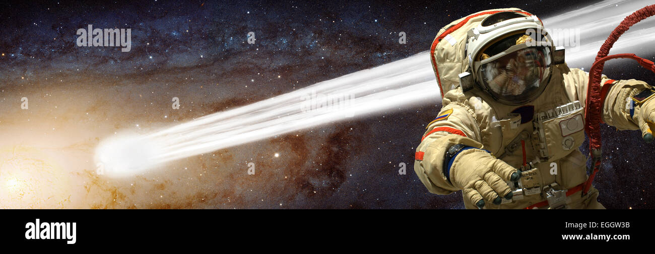 Un cosmonaute flotte dans l'espace profond tout en attaché à son navire. Une comète passe près de lui sur son chemin vers le soleil il orbite Banque D'Images