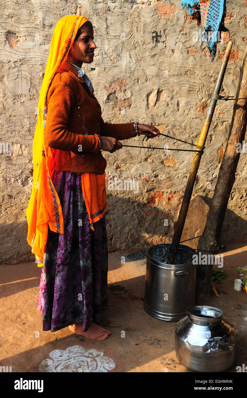 Femme indienne le barattage du beurre dans son village tribal Madhya Pradesh, Inde Banque D'Images