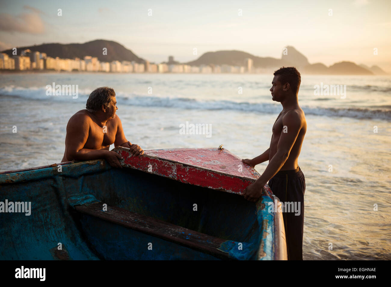 Les pêcheurs de prendre leurs bateaux à l'aube, la plage de Copacabana, Rio de Janeiro, Brésil Banque D'Images