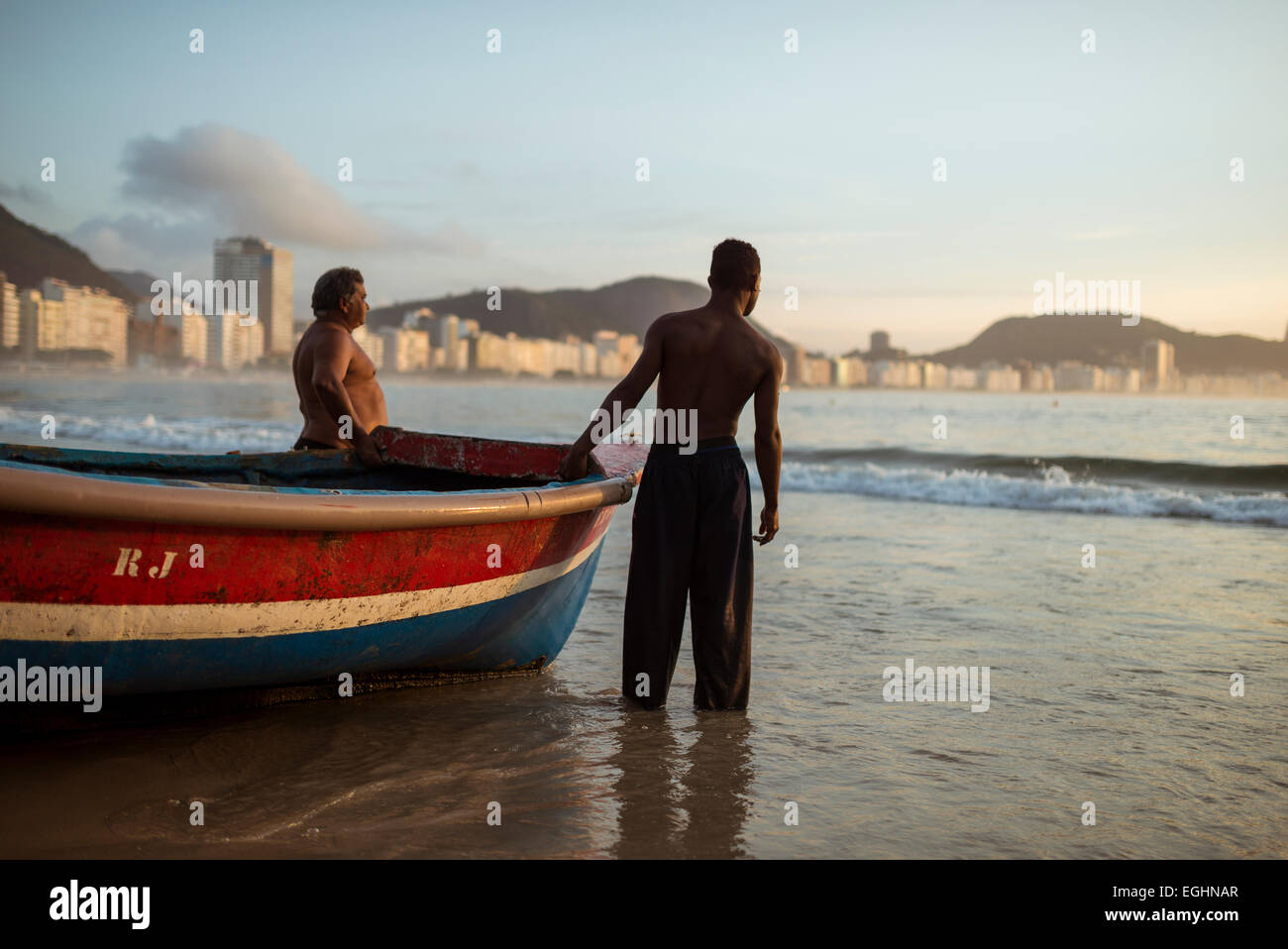 Les pêcheurs de prendre leurs bateaux à l'aube, la plage de Copacabana, Rio de Janeiro, Brésil Banque D'Images