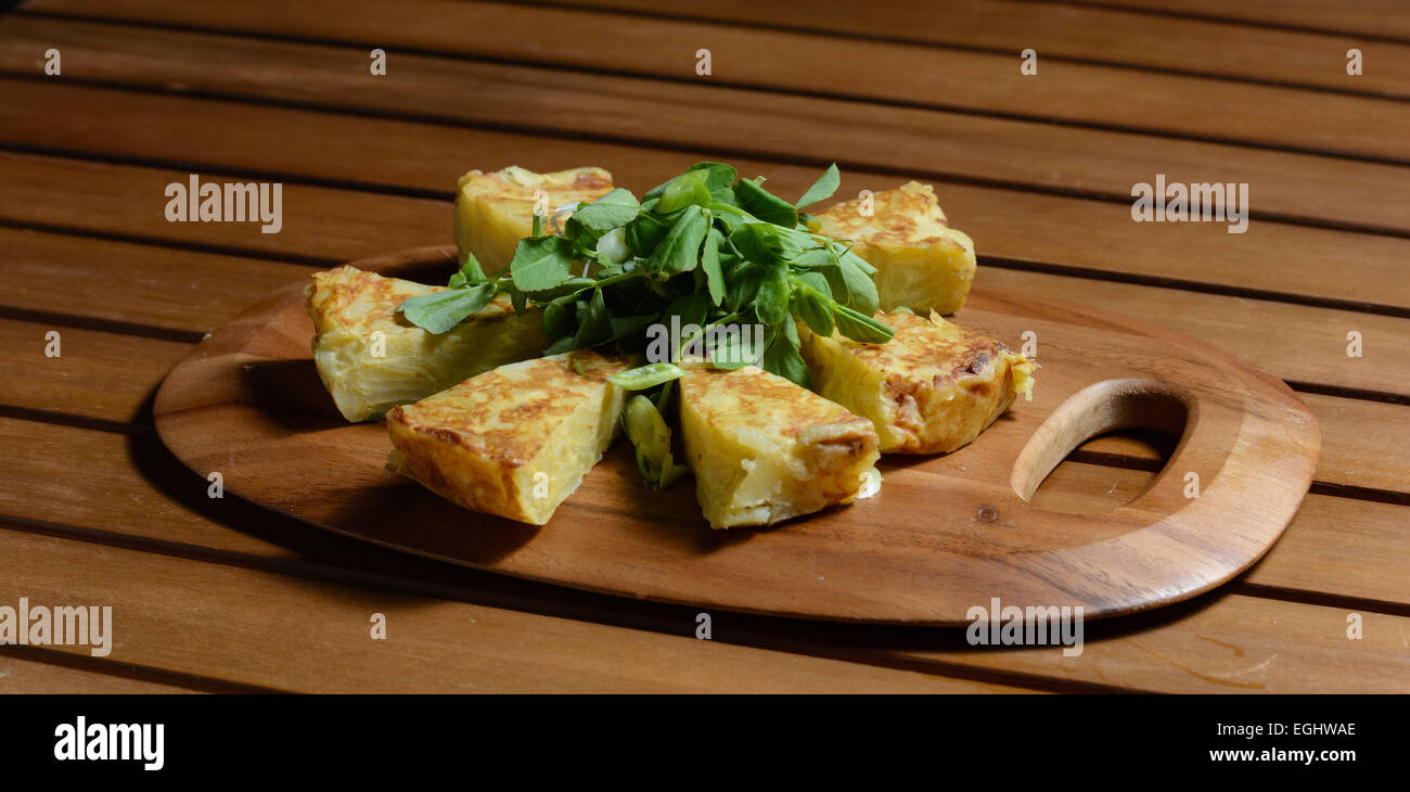 L'omelette espagnole. Le plat traditionnel espagnol composé d'un oeuf omelette aux pommes de terre ajoutée, onoions rouge et frites dans l'huile vég. Banque D'Images