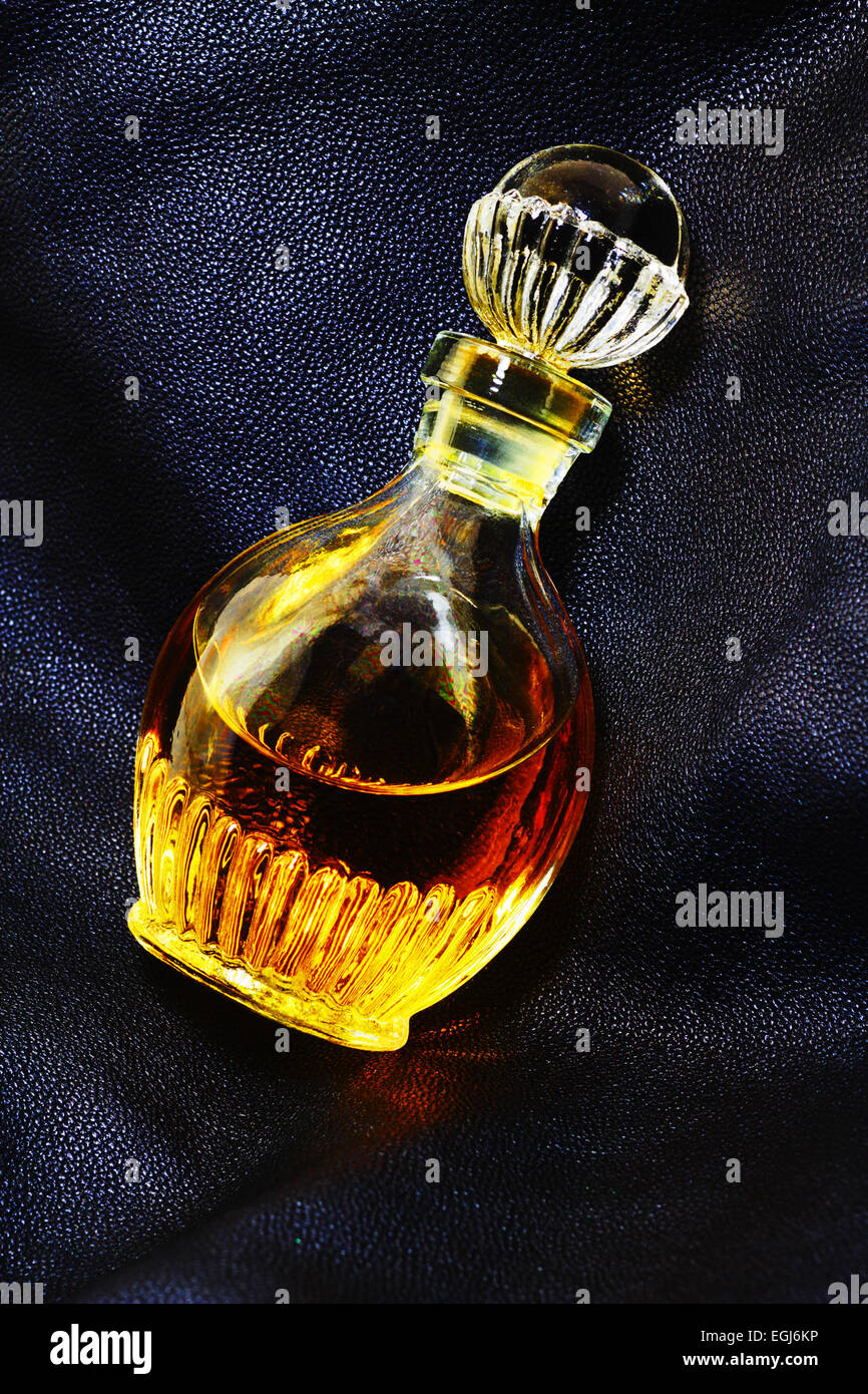 Vintage flacon de parfum sur des articles en cuir. L'éclairage discret Banque D'Images