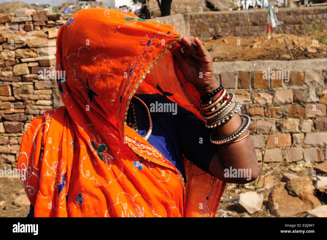 Indian woman face recouverte d'un brignt sari orange montre son silver jewllery Kalpi village tribal Rajasthan Inde Banque D'Images