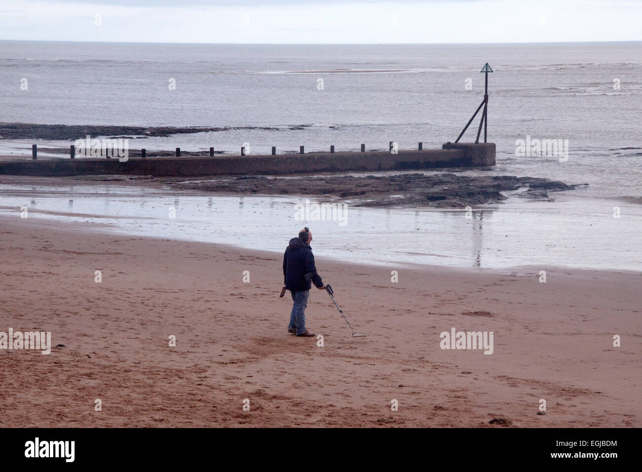 Un homme utilise un détecteur de métaux sur la plage d''Exmouth Banque D'Images