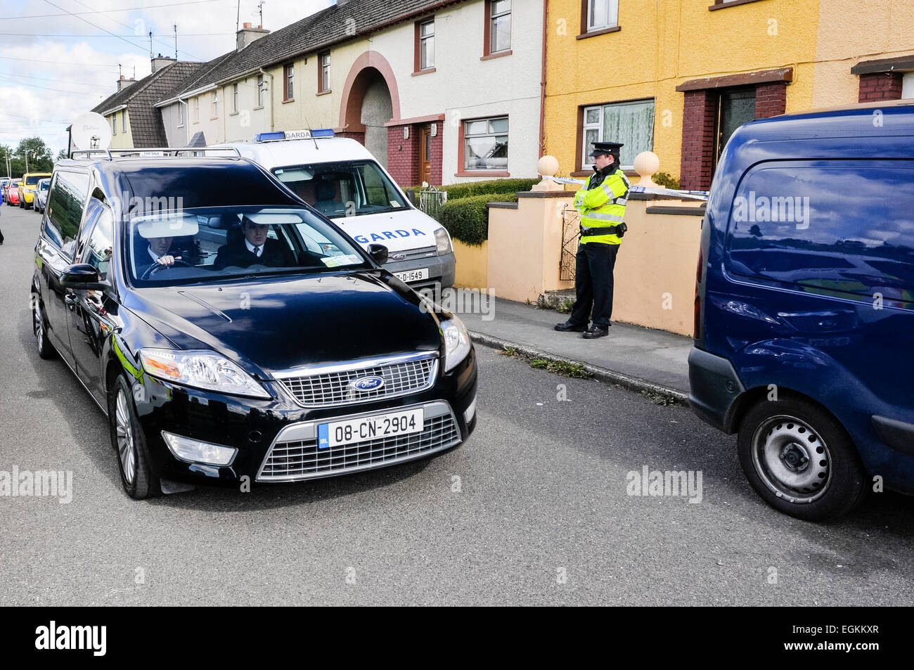 Bailieborough, comté de Cavan, République d'Irlande, 6 septembre 2013 - un corbillard s'arrête à une maison étant gardé par un officier Garda Siochana après qu'un corps avait été trouvé. Banque D'Images