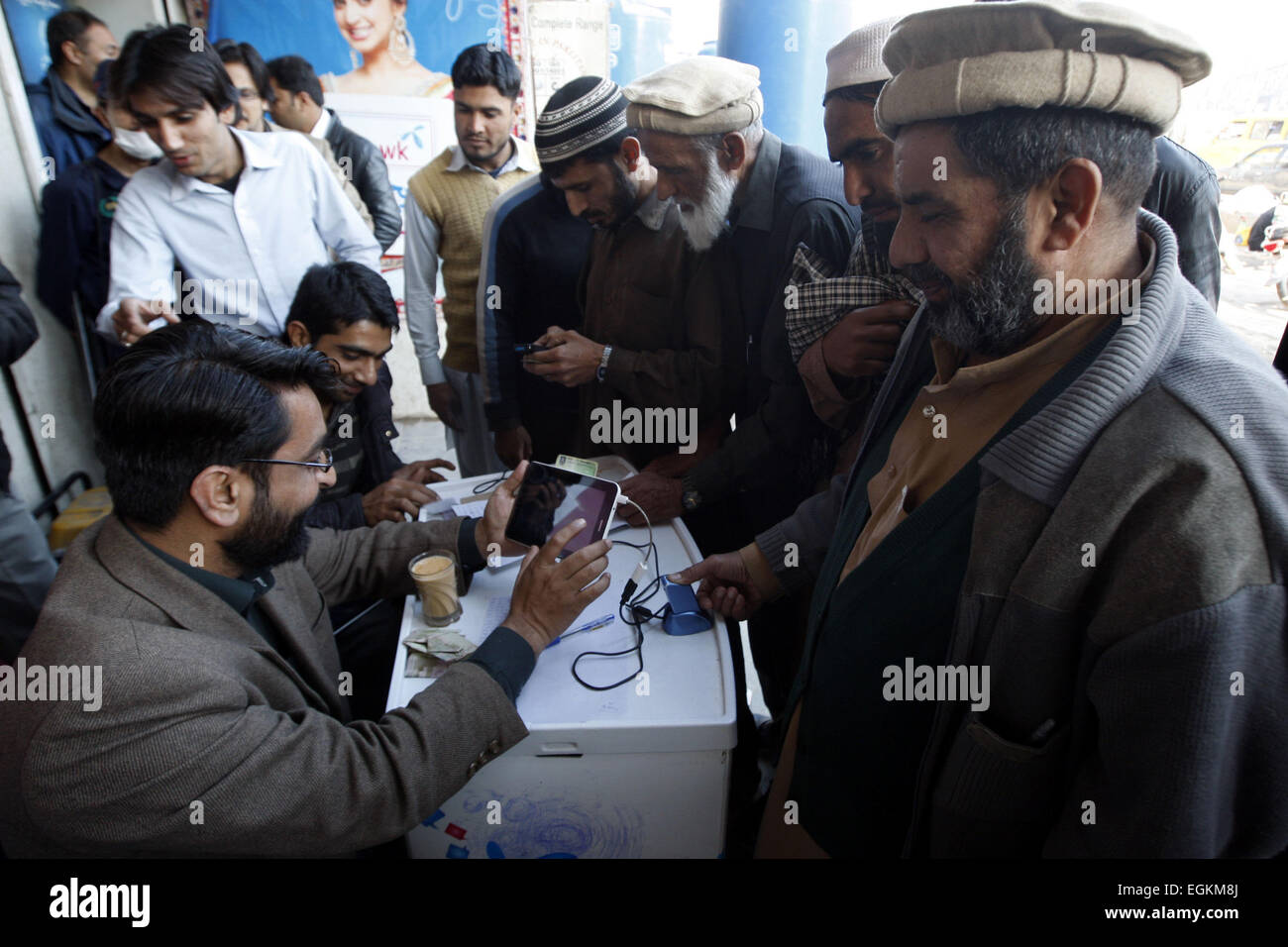 Peshawar. Feb 26, 2015. Les gens ont leurs empreintes digitales numérisées pour avoir une carte SIM de téléphone portable vérifiée dans le nord-ouest du Pakistan, Peshawar, 26 février 2015. Les Pakistanais se sont disputés à scanner leurs empreintes digitales et vérifier leur identité afin de garder leur téléphone cellulaire, dans le cadre des mesures de sécurité à la suite de l'attaque de l'école Décembre Peshawar. © Umar Qayyum/Xinhua/Alamy Live News Banque D'Images