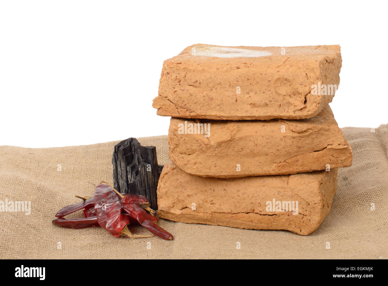 Meju (montant forfaitaire de soja fermentée) et d'ingrédients de base pour faire doenjang, isolé sur blanc. Banque D'Images