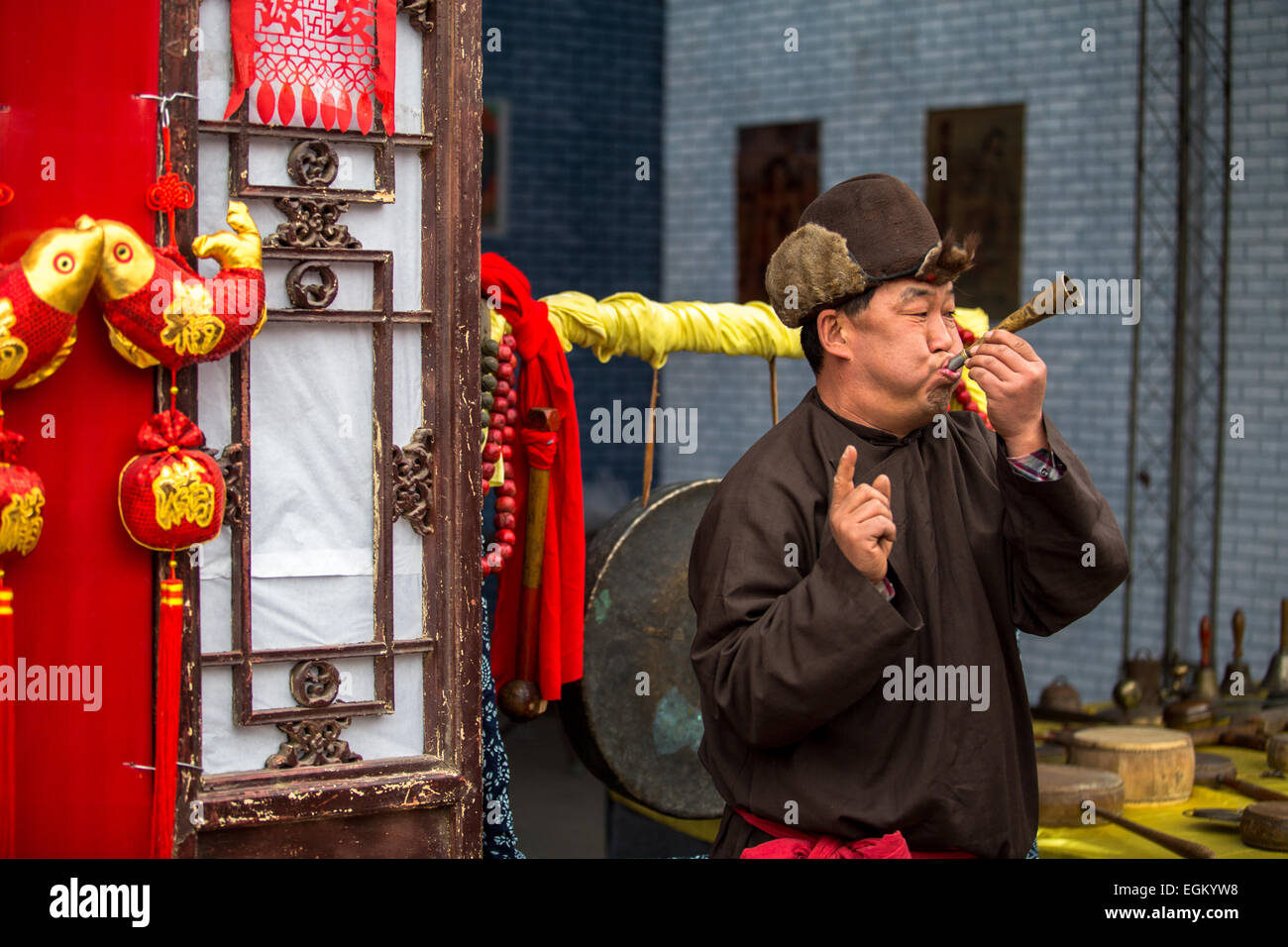 Un artiste populaire souffler dans la trompette ancienne foire du temple. Banque D'Images