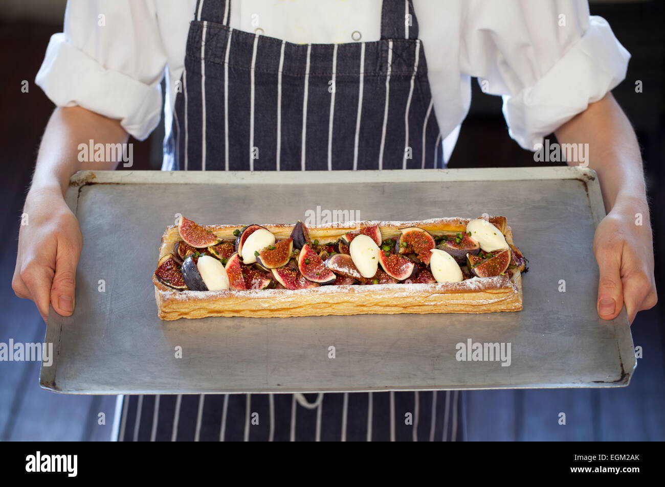 Bac de cuisine Chef holding Fig tarte avec du fromage et pistaches Banque D'Images