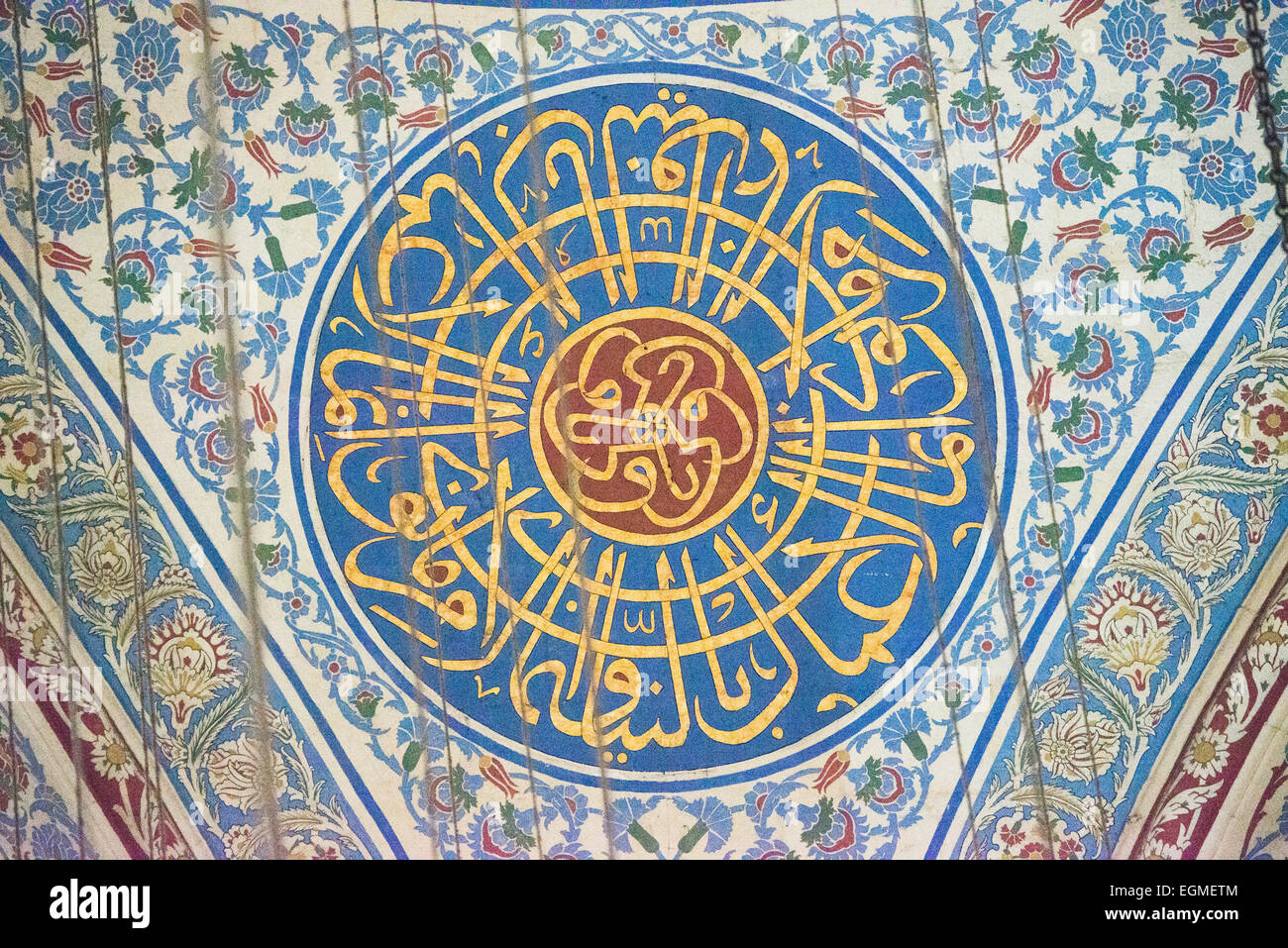 Calligraphie du dôme de la mosquée du sultan Ahmed Istanbul // ISTANBUL, Turquie — le sommet richement décoré du dôme central de la mosquée du sultan Ahmed présente une calligraphie islamique complexe et des motifs géométriques. Le design élaboré du dôme combine des versets du Coran avec des motifs artistiques ottomans traditionnels. La décoration peinte représente l'apogée de l'art religieux ottoman du XVIIe siècle. Banque D'Images