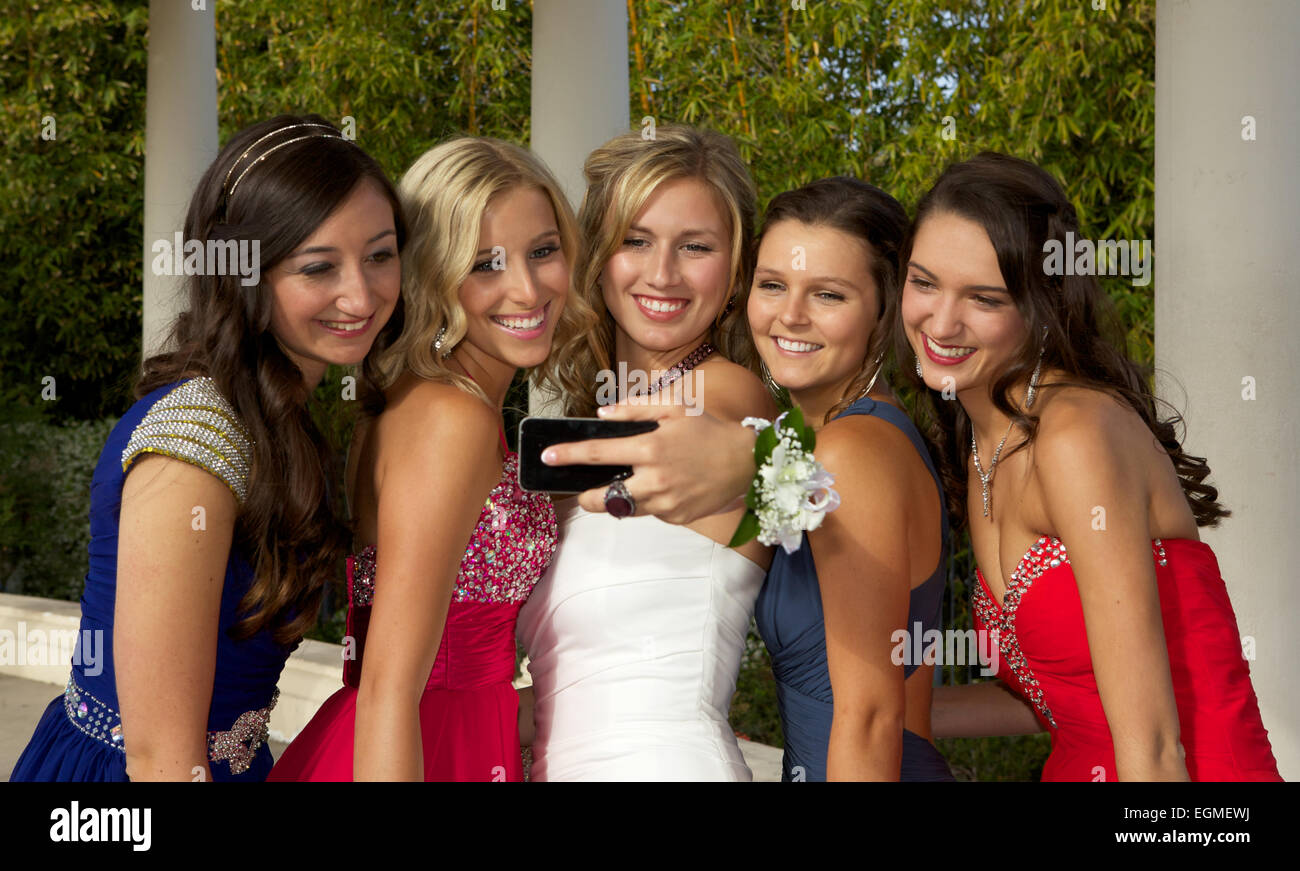 Cinq belles jeunes filles en robe de soirée de prendre un sur un téléphone cellulaire Selfies en dehors Banque D'Images