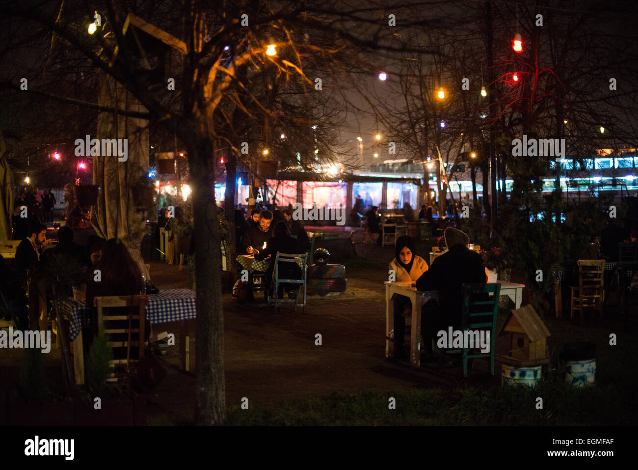 ISTANBUL, Turquie / Türkiye — les convives mangent dans des restaurants extérieurs pop-up sur les rives de la Corne d'Or à Karakoy, avec le pont de Galata et la Nouvelle Mosquée en arrière-plan. Banque D'Images