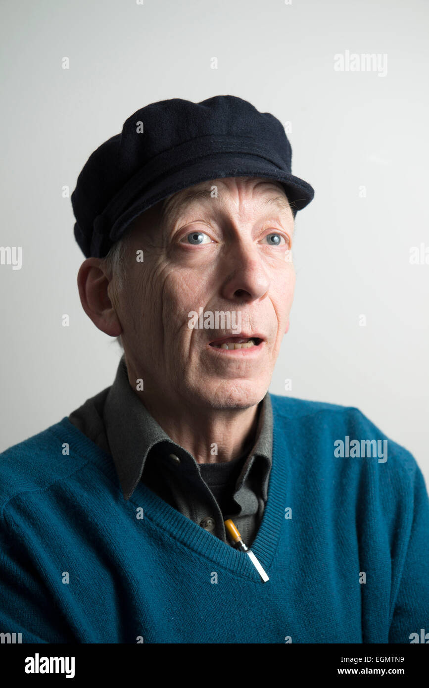 Drôle de caractère vieux sage homme âgé a atteint un sommet dans un chapeau, col en v pull sweater jumper, avec des stylos à l'image d'un mad professor Banque D'Images